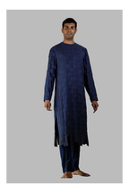 Man wearing a dark blue traditional outfit on a gray background