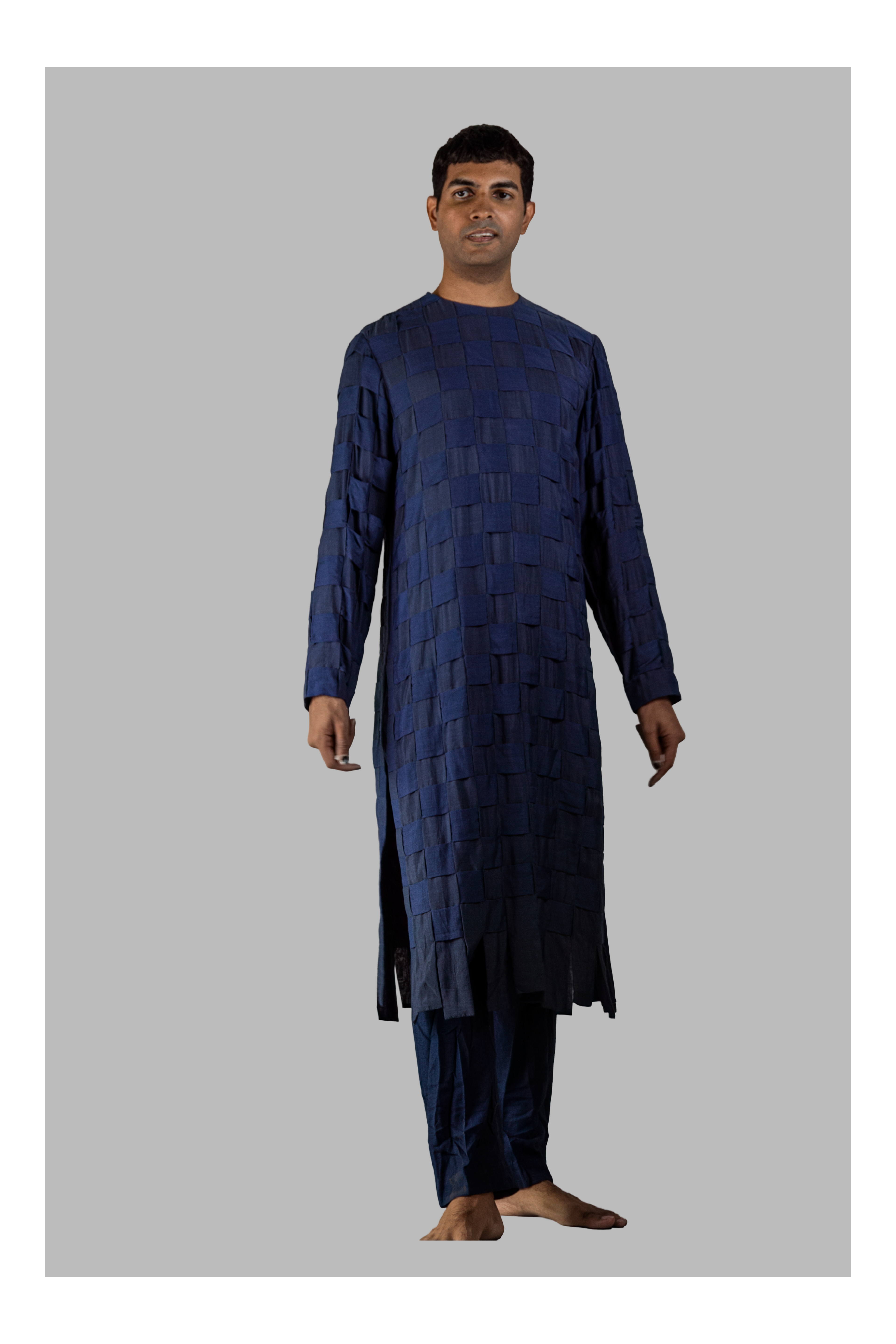 Man wearing a dark blue traditional outfit on a gray background