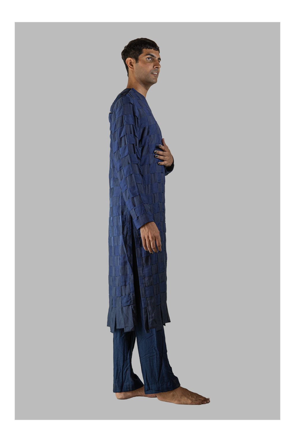 Man wearing a blue traditional outfit on a gray background