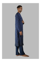 Man wearing a blue traditional outfit on a gray background
