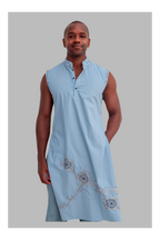 Man wearing a light blue sleeveless top with embroidery on a gray background