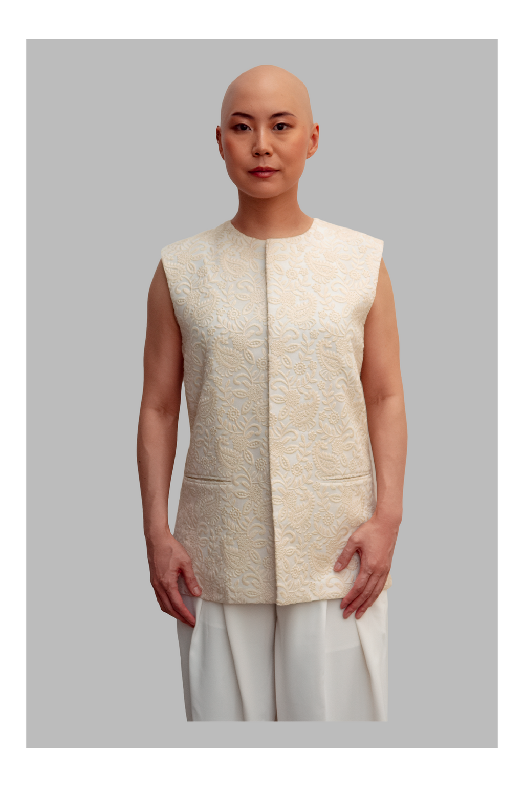 Female wearing a white vest with a textured pattern on a gray background