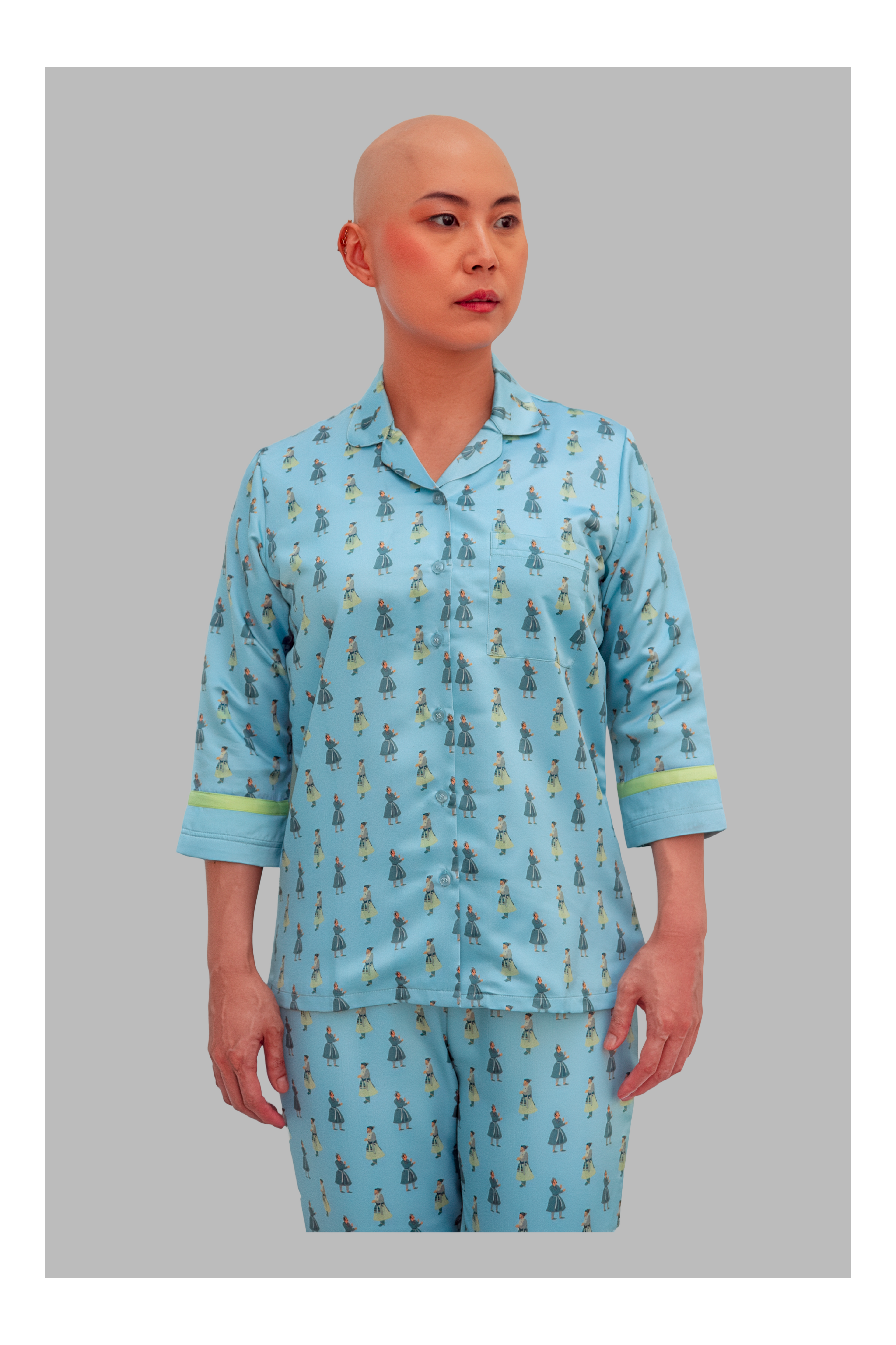 Person wearing a blue pajama set with a pattern on a gray background