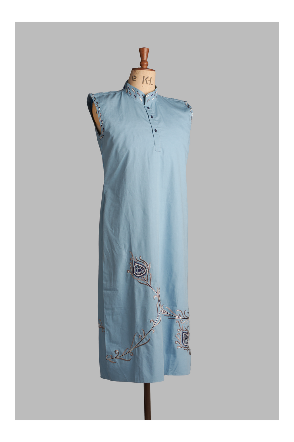 Light blue sleeveless dress with embroidery on a mannequin against a gray background
