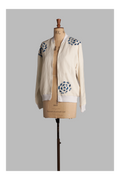 Mannequin wearing a white-colored bomber jacket with blue floral patterns on a gray background