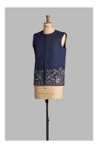 Navy blue vest with floral embroidery on a mannequin against a gray background