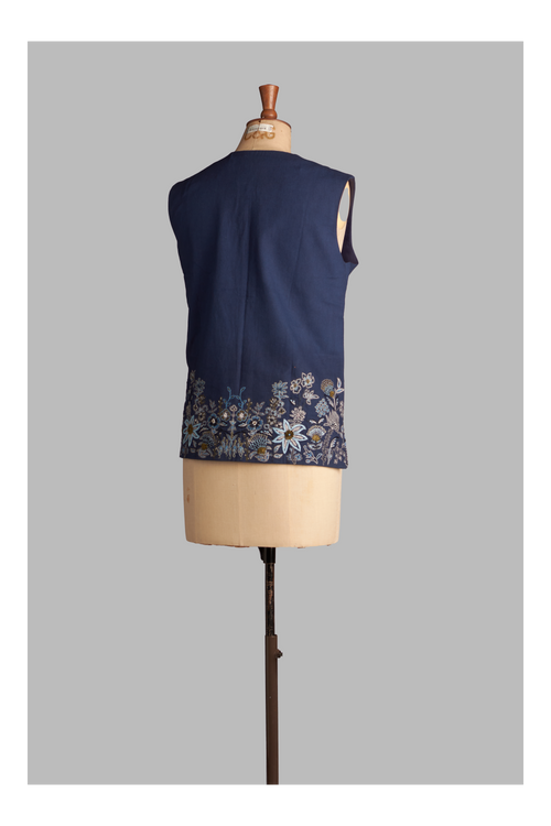 Navy blue sleeveless top with floral embroidery on a mannequin against a gray background