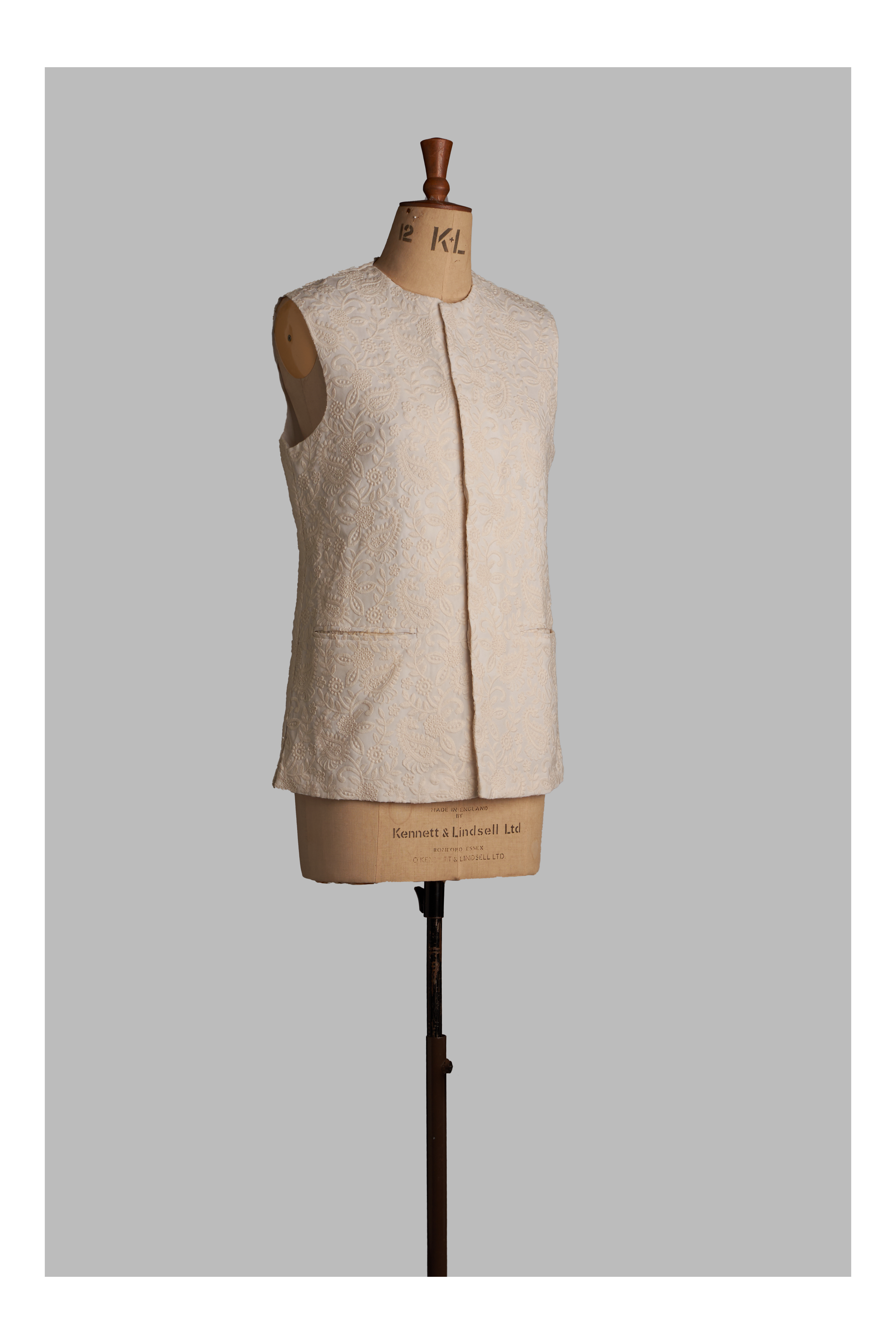 White vest on a mannequin against a gray background