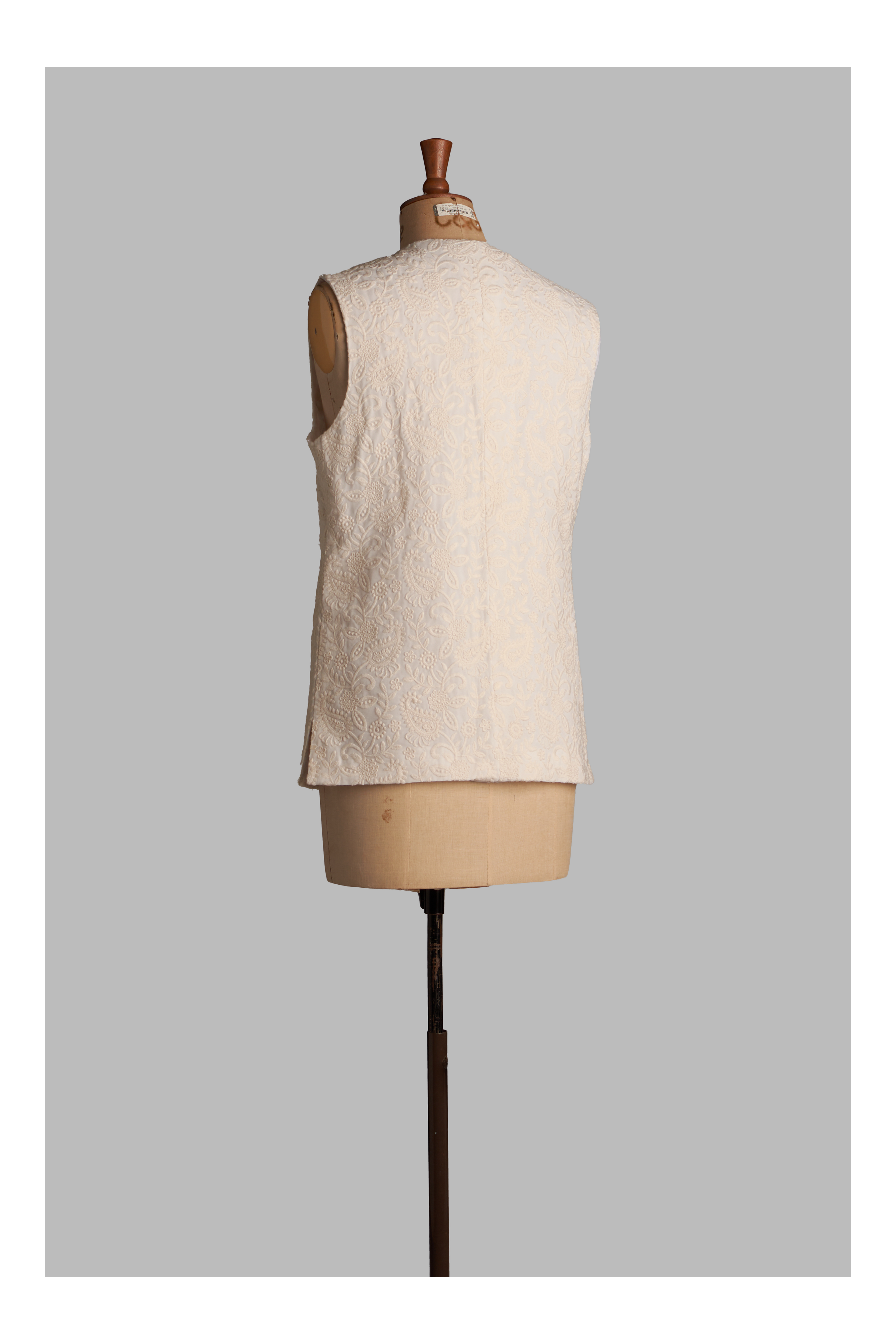 White vest on a mannequin against a gray background