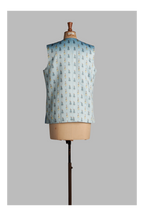 Light blue sleeveless vest with a pattern on a mannequin against a gray background