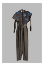 grey jumpsuit with belt and detachable collar accents on a grey background