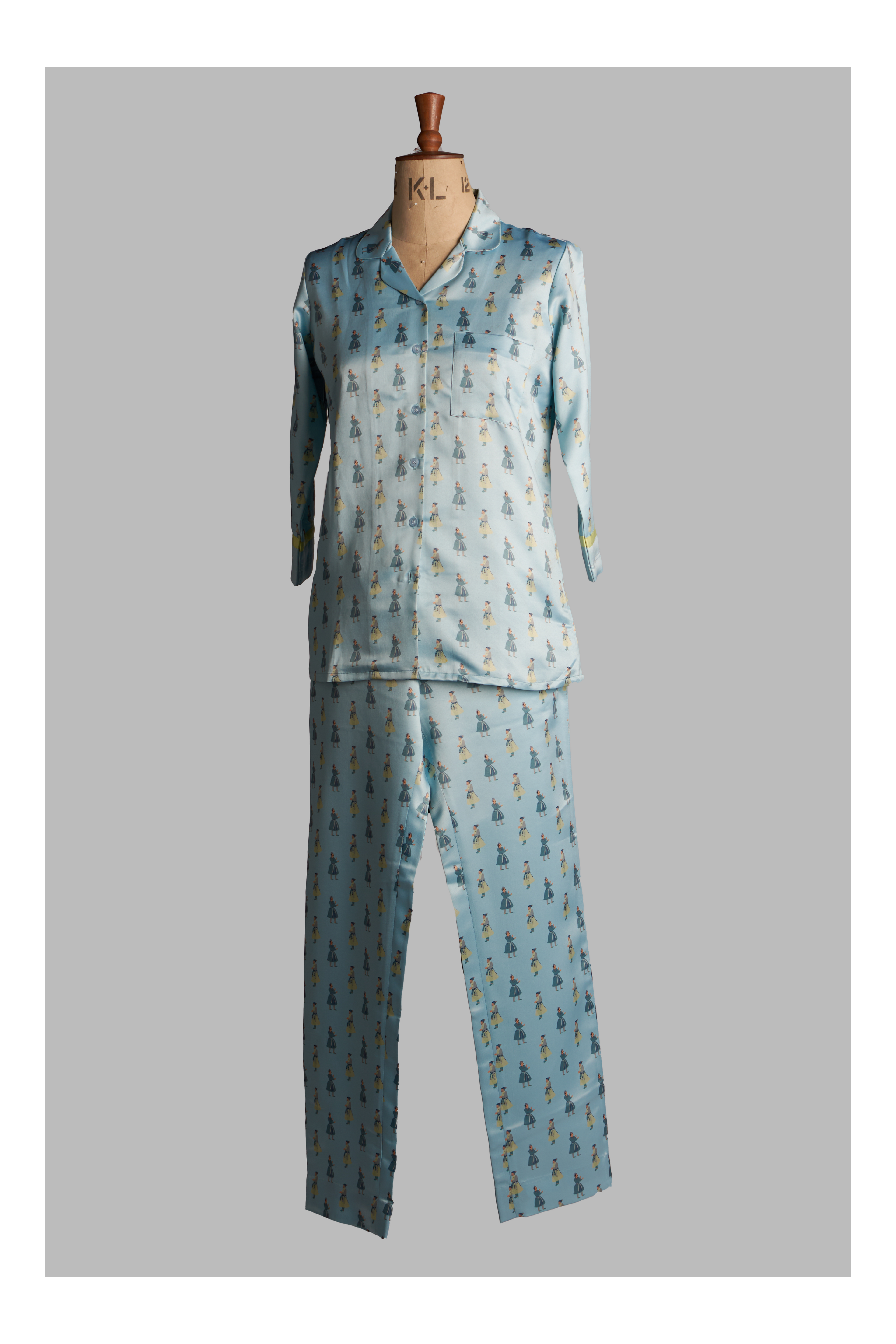 Light blue pajama set with a pattern on a mannequin against a gray background
