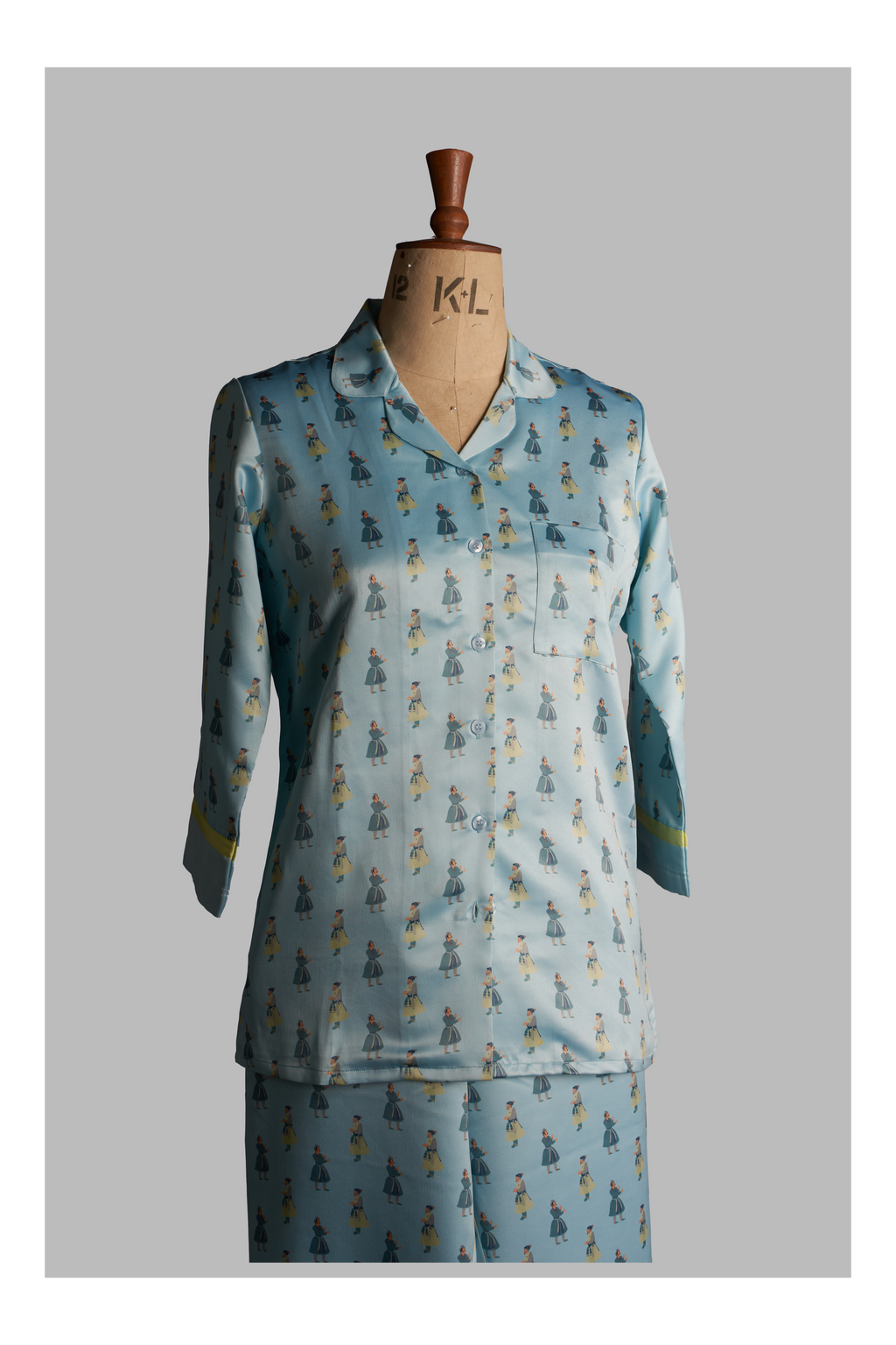Light blue pajama set with a pattern on a mannequin against a gray background