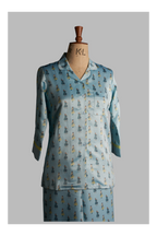 Light blue pajama set with a pattern on a mannequin against a gray background